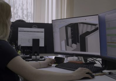 Sedentary work at the computer. Creative. A young woman with long hair is sitting at her workplace in a warm office and creating projects on a computer. High quality 4k footage